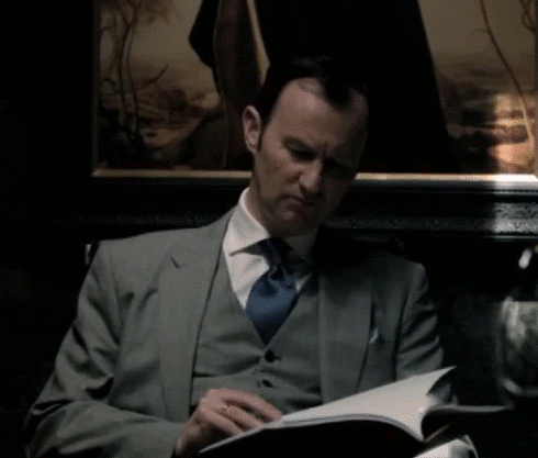 Mycroft at desk looking up