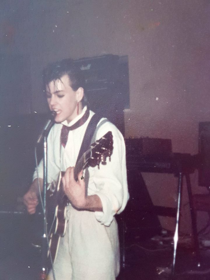 A young Rupert Graves rocking out.