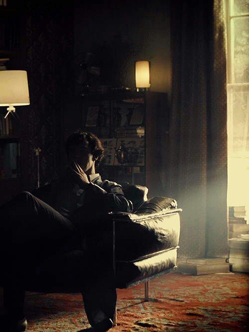 Sherlock deep shadowed in his chair thinking