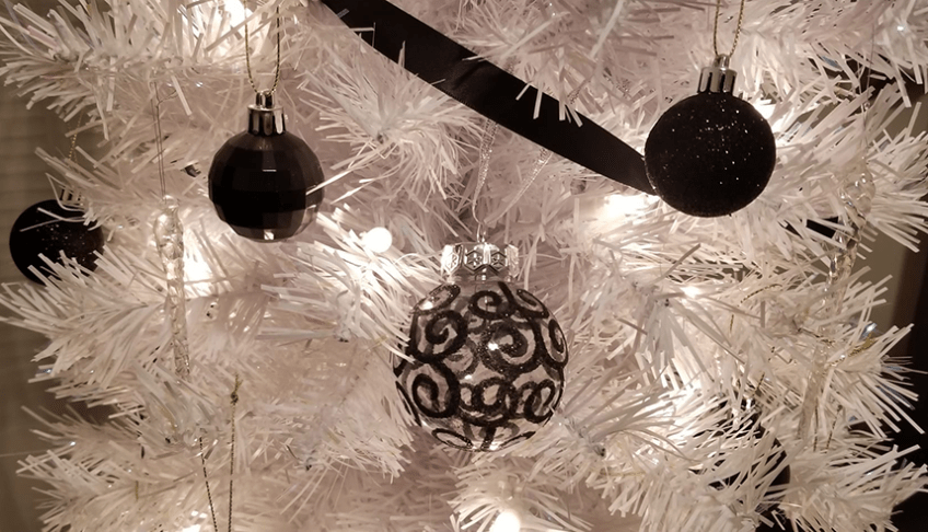 A white Christmas tree with black ornaments