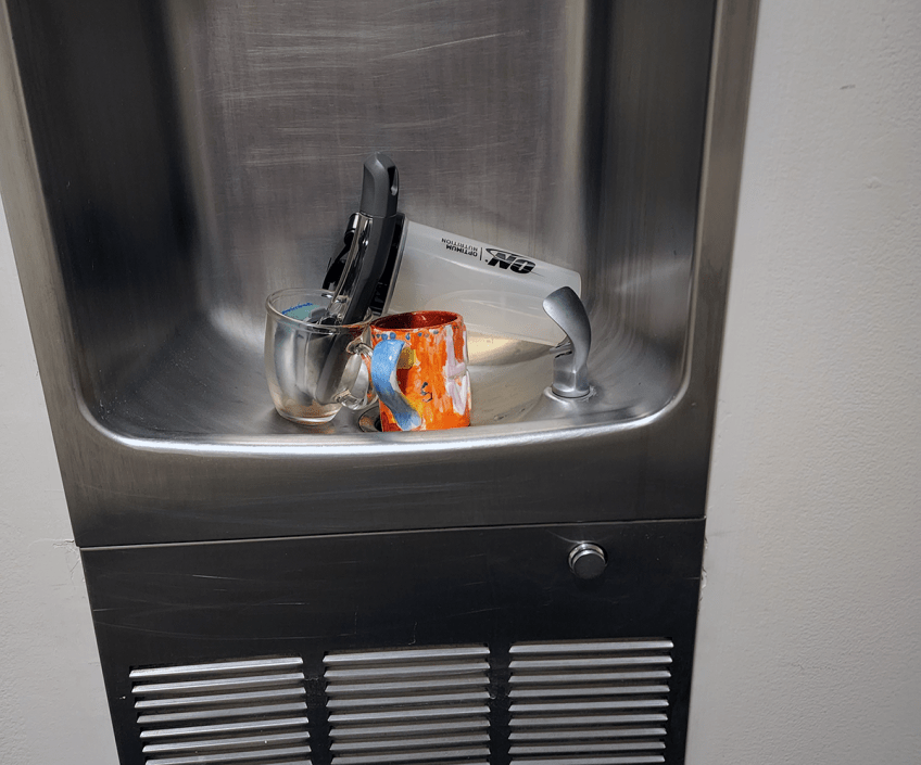 Office water fountain with dirty dishes